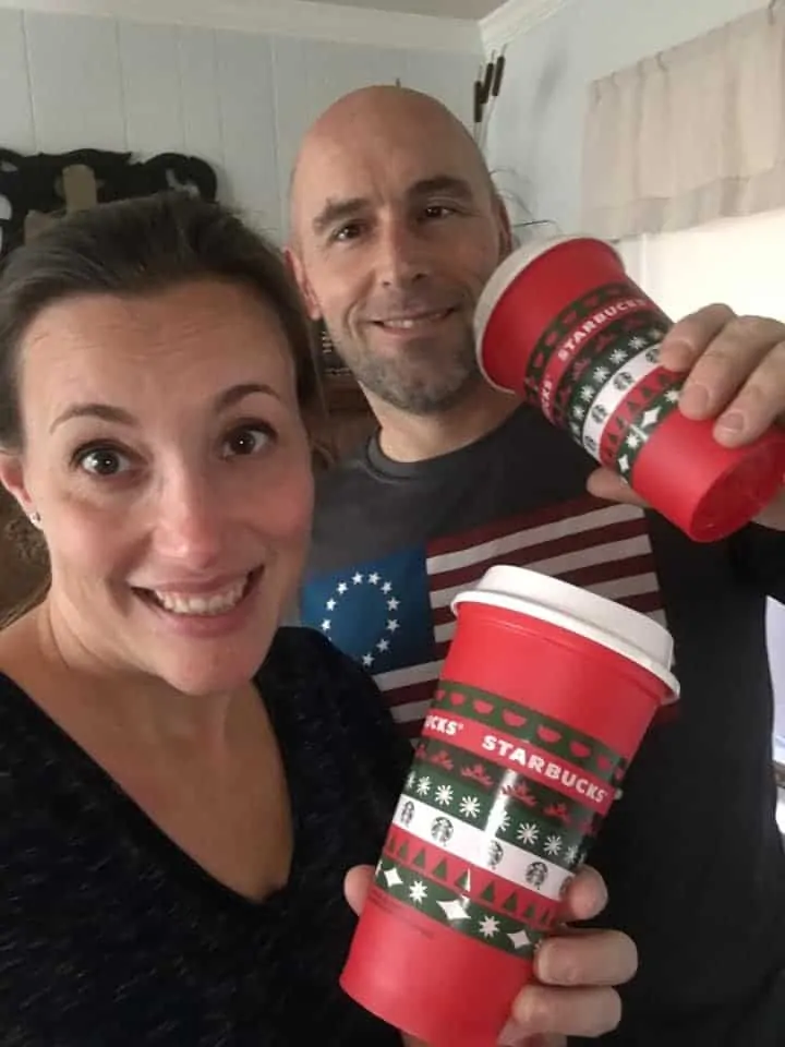 A happy couple with Starbucks coffee cups.
