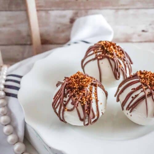 White chocolate mocha hot chocolate balls drizzled with milk chocolate on top.