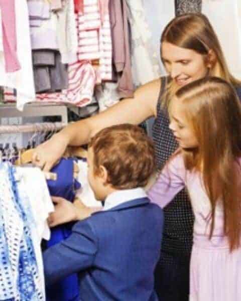 A mom shopping with her children for clothes.