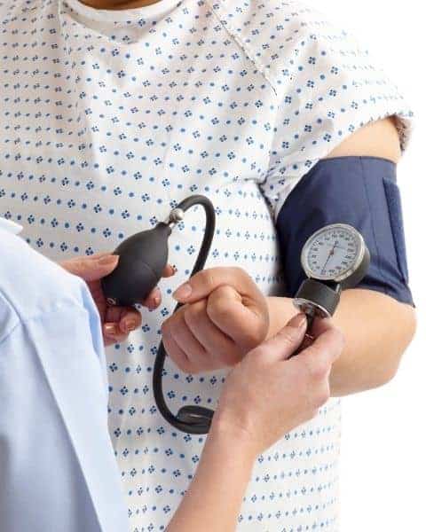 Nurse taking the blood pressure of a patient.