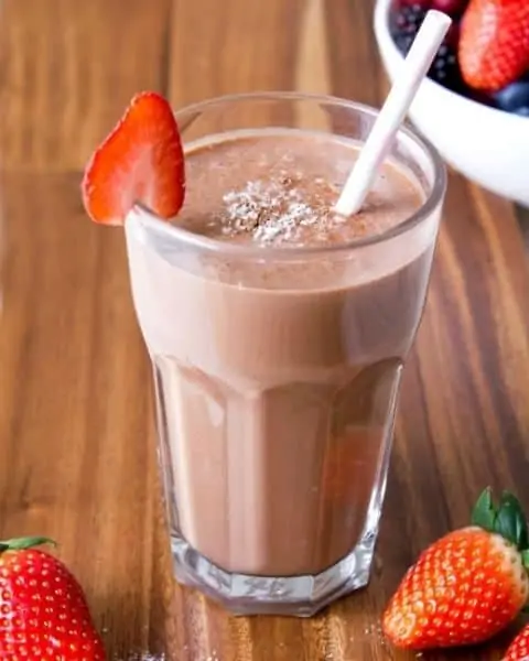 Chocolate strawberry smoothie with straw.