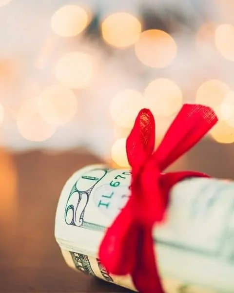 a roll of cash wrapped in a red ribbon.
