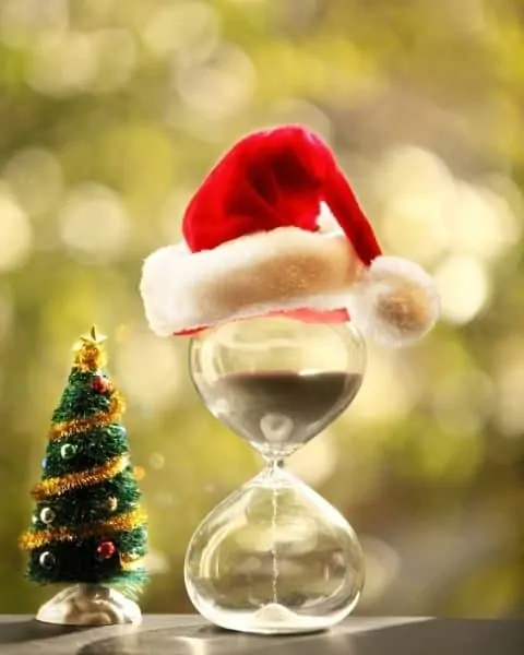 Full hourglass with a Santa hat on top.