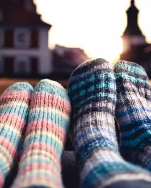 Two people wearing cozy woolen socks watching a movie.