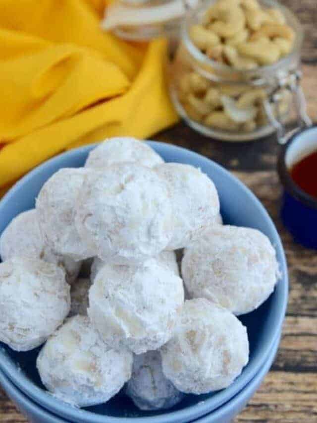 Snowball cookies in a blue bowl.