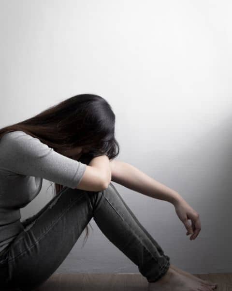 A woman holding her head in her hands.