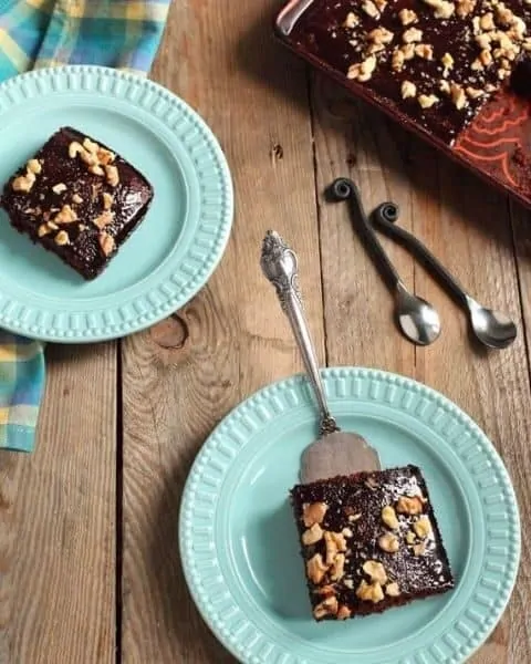 Slices of einkorn Texas sheet cake with chopped walnuts on top.