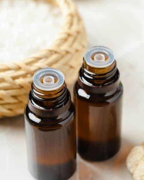 Two empty essential oil jars next to a wicker basket.