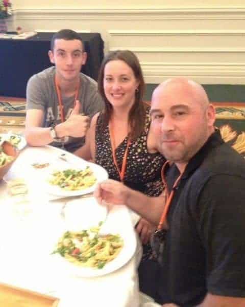 Three people sitting at a dining table together enjoying family dinner.