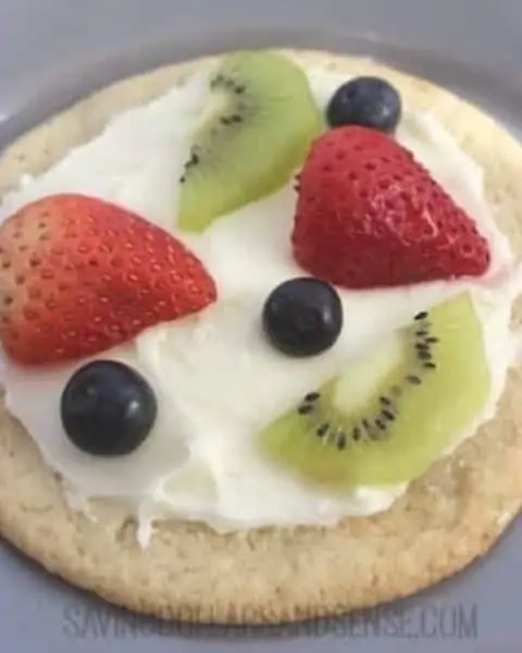 Small fruit pizza with strawberries, blueberries, and kiwis.