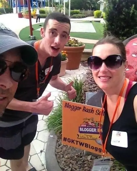 A small group of grownups standing in front of a Blogger Bash Self sign.