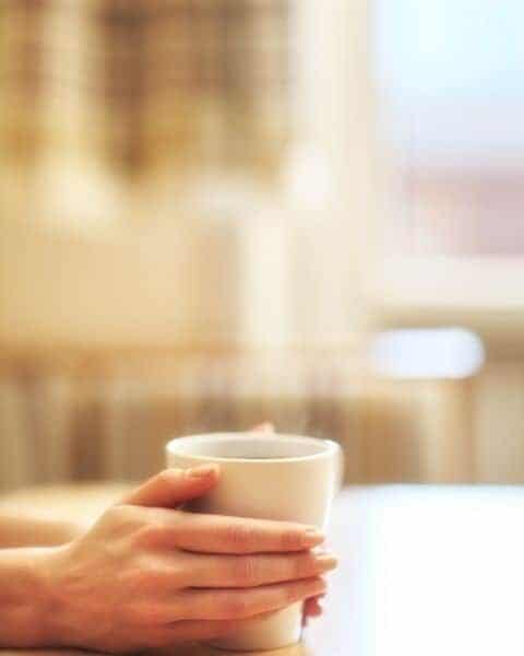 A woman holding a cup of coffee in her hands.