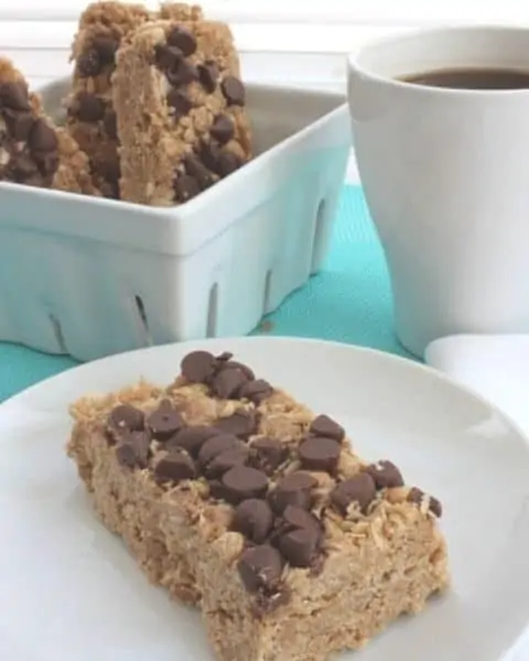 A homemade chocolate chip and peanut butter granola bar is sitting on a white plate.