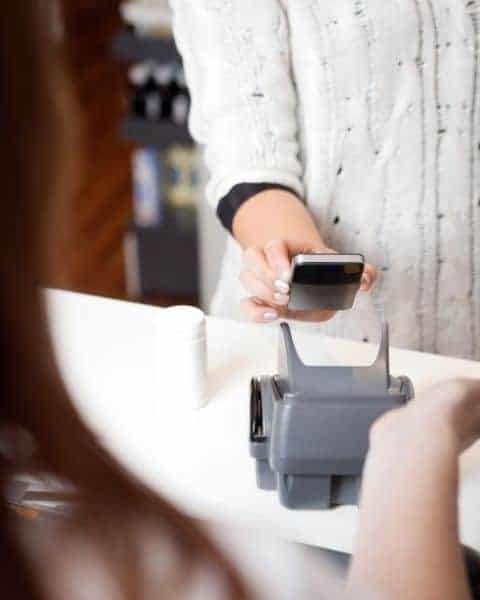 A woman scanning her phone to pay for groceries and use mobile coupons.