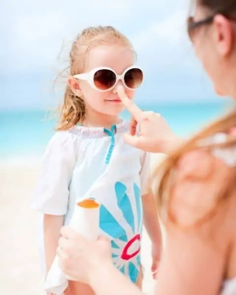 A mom putting homemade sunscreen on her daughter.