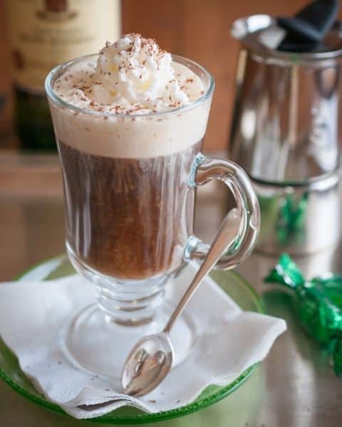 A cup of homemade Irish coffee with whip cream and cinnamon sprinkled on top.