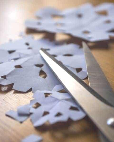 Scissors with cut out snowflakes.