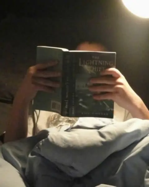 A young man reading The Lightning Thief.