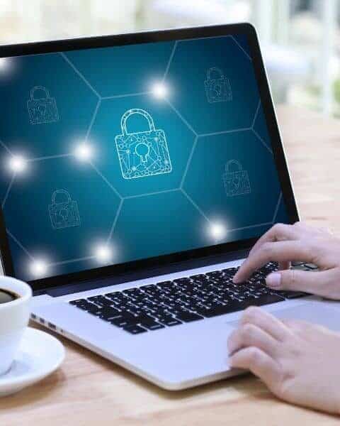 A woman typing on her laptop with an image of a locked key.