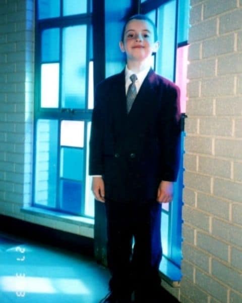 A little boy in a suite and tie.