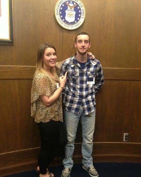 A woman and man standing next to each other with their arms around each other.