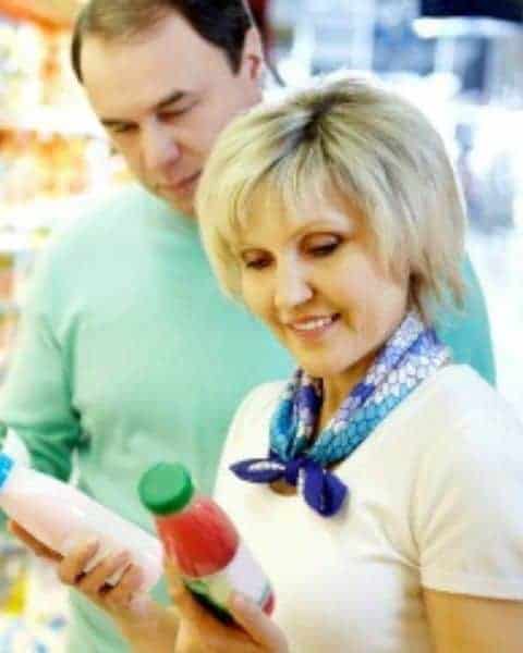 A man and a woman looking at two different bottles of products.