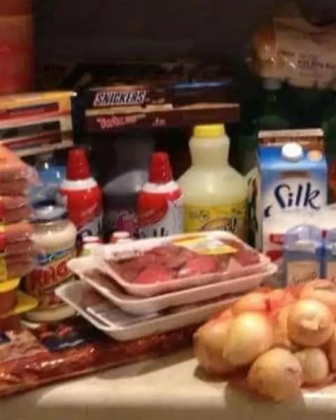 Grocery haul with whip cream, produce, meat, and milk.