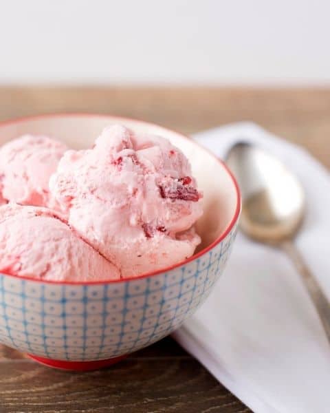 A close up of a bowl of strawberry ice cream.