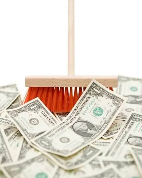 Broom sweeping up money.