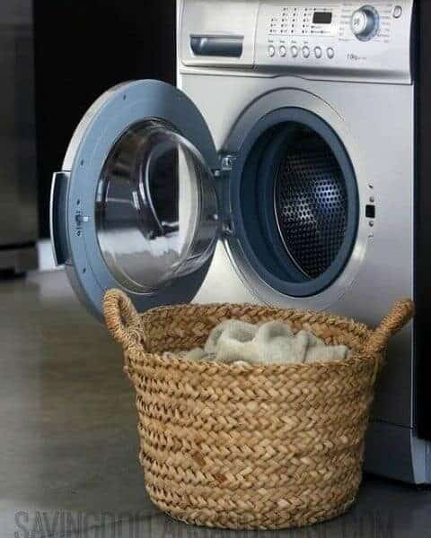 Washing machine with a full wicker basket in front of the machine.