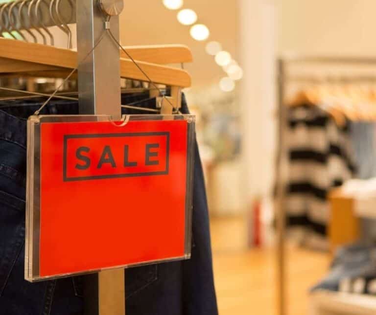 A red sale sign on a clothes wrack at the department store.