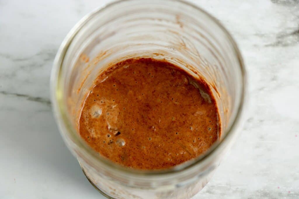 All of the ingredients mixed together in a mason jar for a chocolate mug cake. 