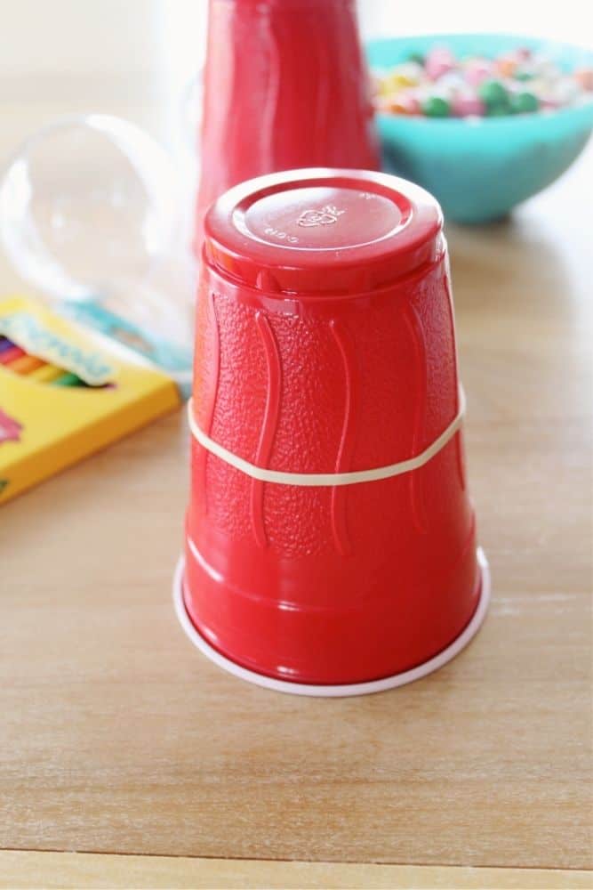 A rubberband wrapped around a Red plastic cup. 