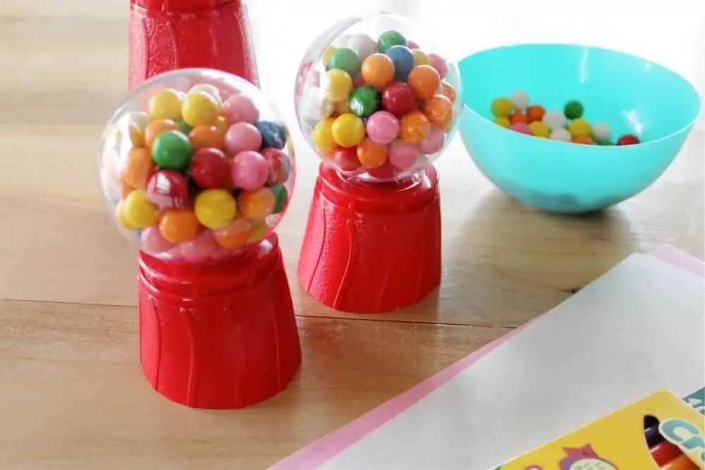 Two almost finished DIY gumball machines sitting on a table.