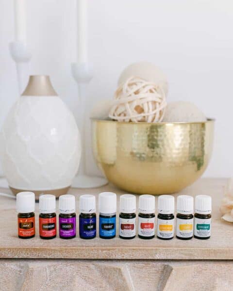 A display of Young Living essential oils lined up on a table.