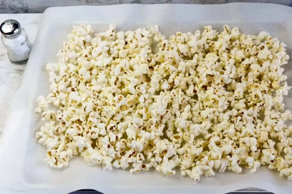 popped popcorn on a lined cookie sheet. 