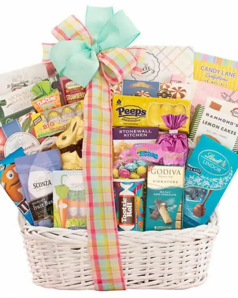 Wicker basket with boxes and bags of Easter candy and sugar treats.