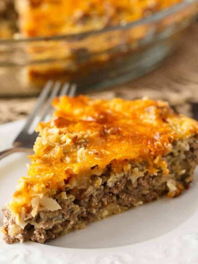 A cooked slice of cheeseburger pie on a white plate.
