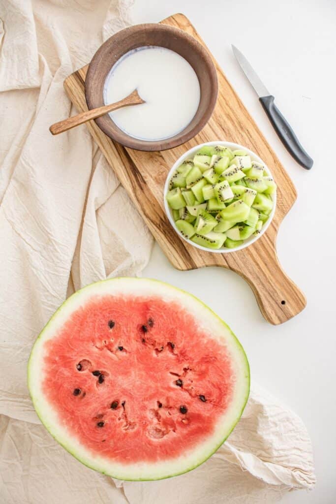 Bowl of cream, sliced kiwi, and watermelon. 