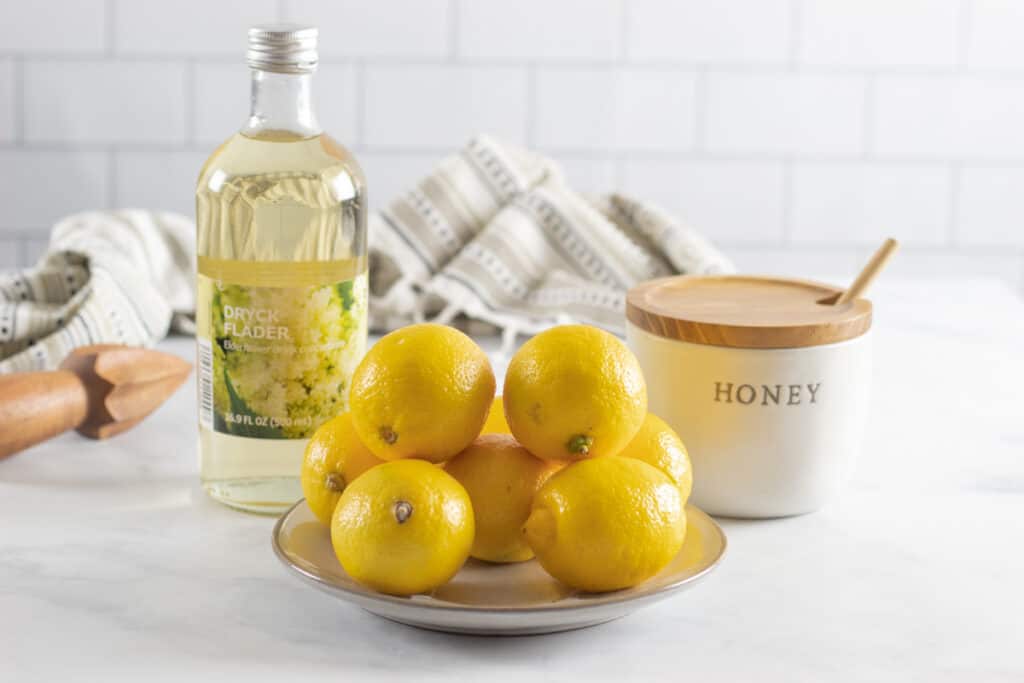 Plate full of lemons and a pot of honey.