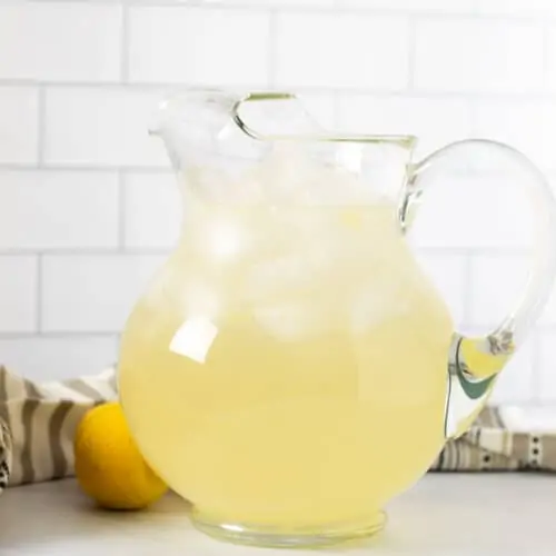 A lemonade pitcher on a counter top.
