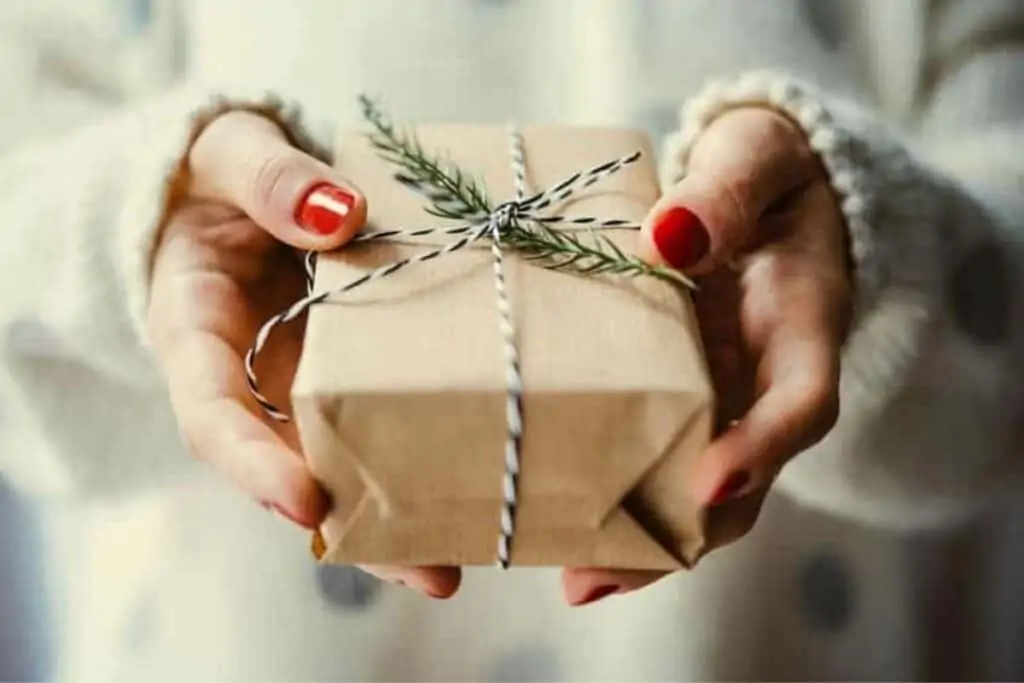 A woman holding a wrapped Christmas gift.