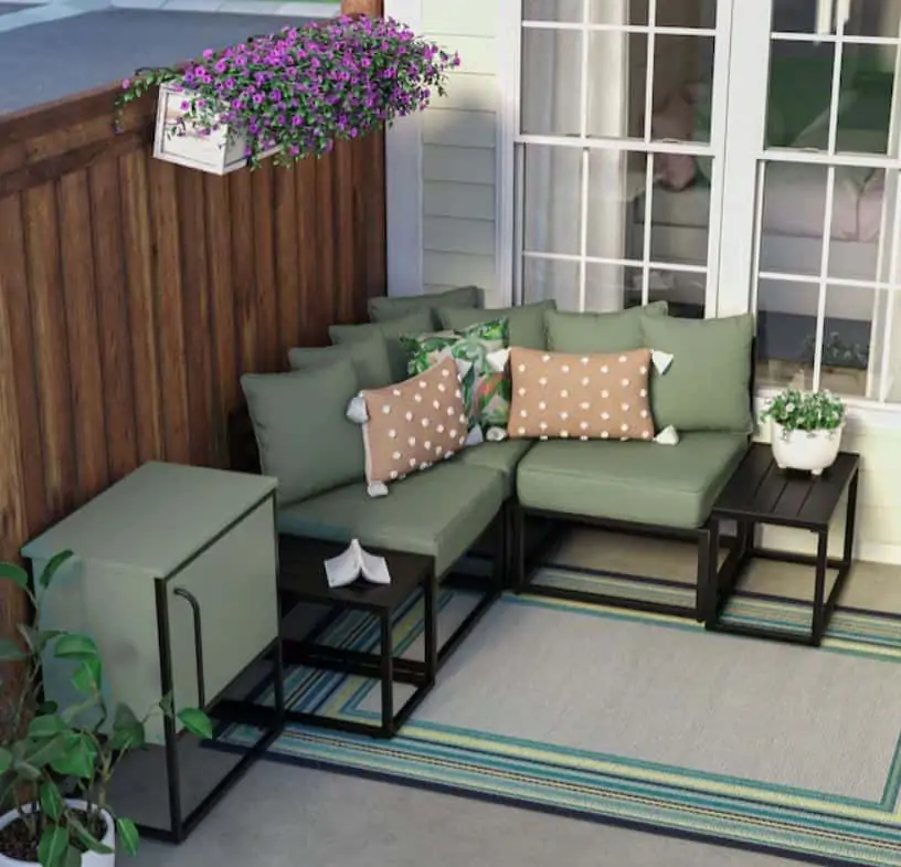 Outdoor furniture with several pillows and end tables.