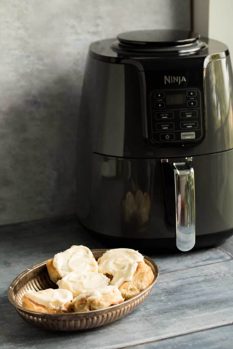 A small basket full of air fryer cinnamon rolls.
