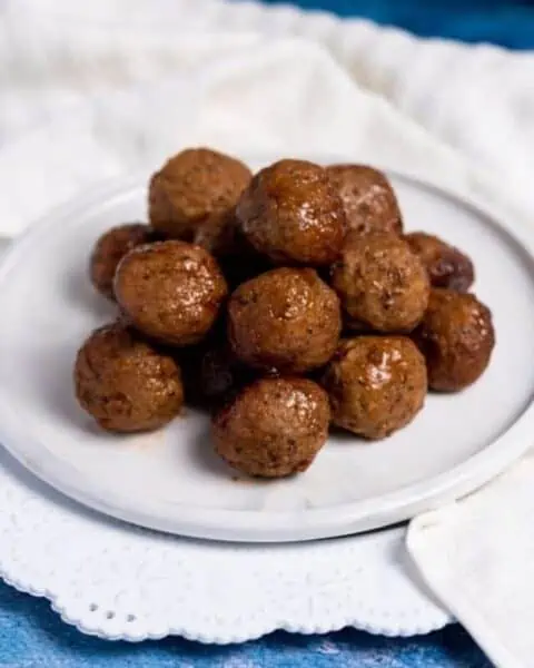 A white plate with grape jelly meatballs instant pot recipe.