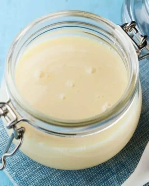 A mason jar full of sweetened condensed milk.