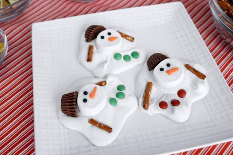 Three melted snowman barks on a white square plate.