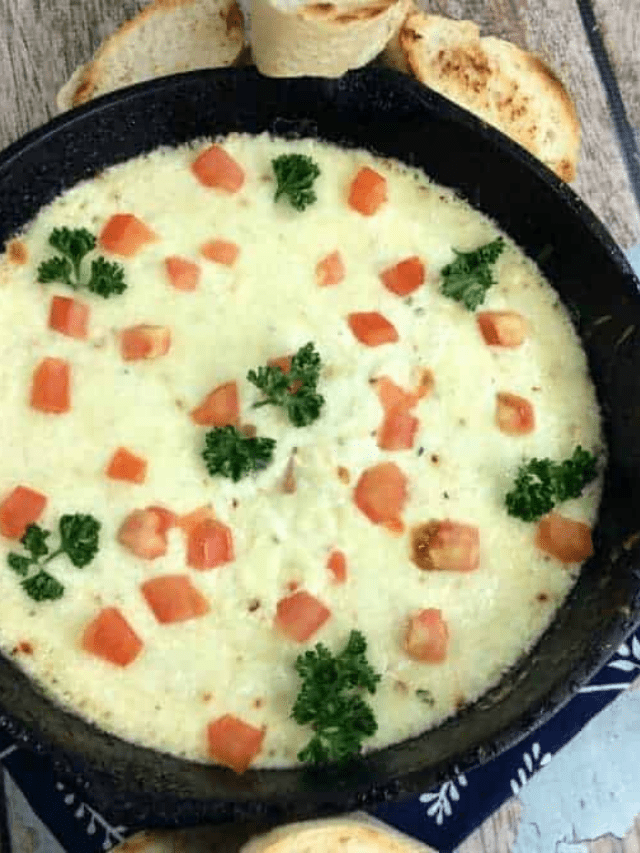 Olive Garden Cheese Fonduta in a black pan surrounded by bread.