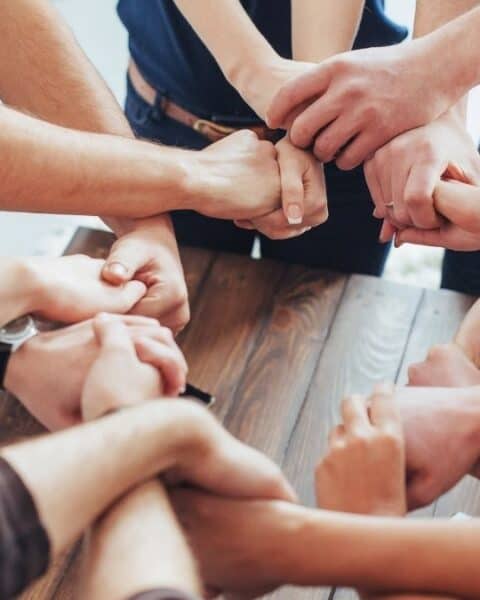 A group of people holding hands with each other.