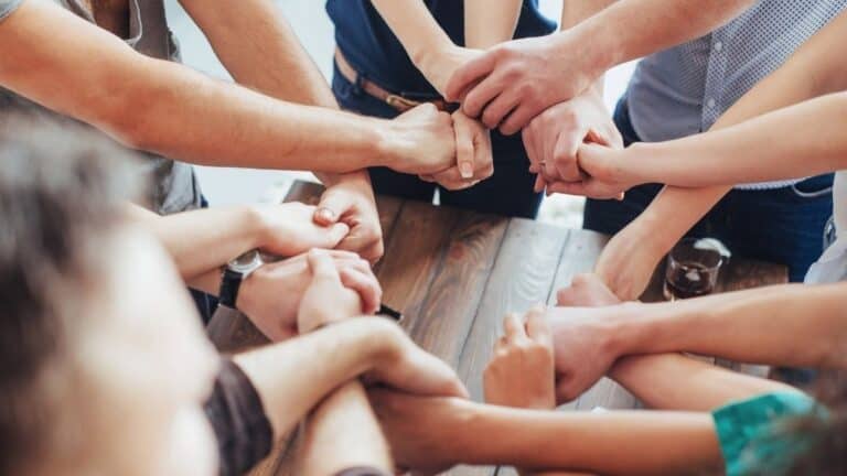 A group of people holding hands with each other.